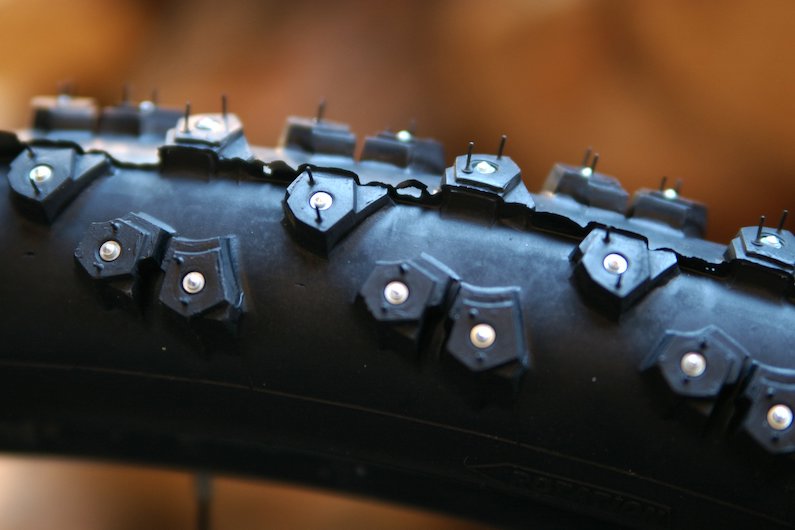 Bicycle tire with tungsten carbide spikes surrounded by aluminum.