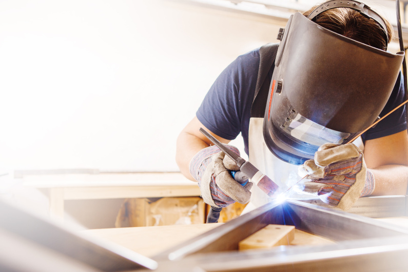 Person TIG welding white background